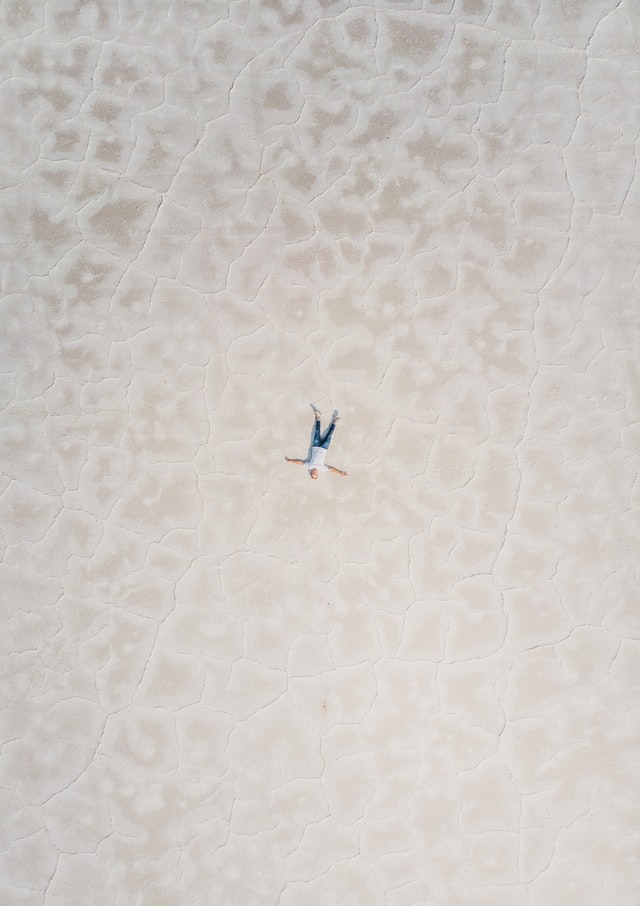 A person laying in a desolate landscape