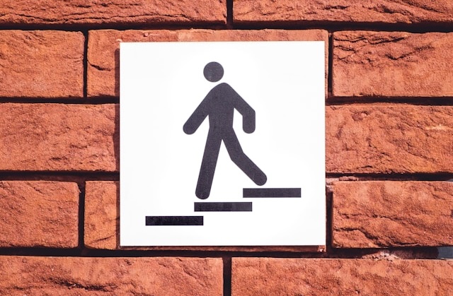 An icon of a person walking down stairs